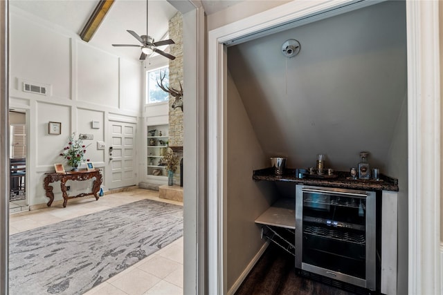 indoor dry bar featuring wine cooler, tile patterned flooring, a ceiling fan, and lofted ceiling