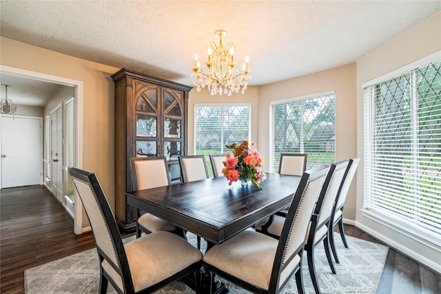 dining space featuring a chandelier, wood finished floors, and baseboards