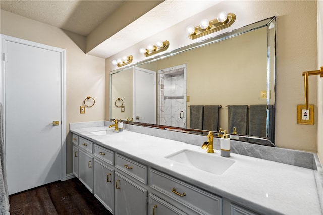 full bath featuring wood finished floors, double vanity, and an enclosed shower