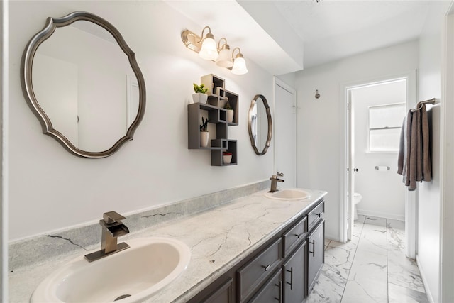 bathroom with marble finish flooring, double vanity, and toilet