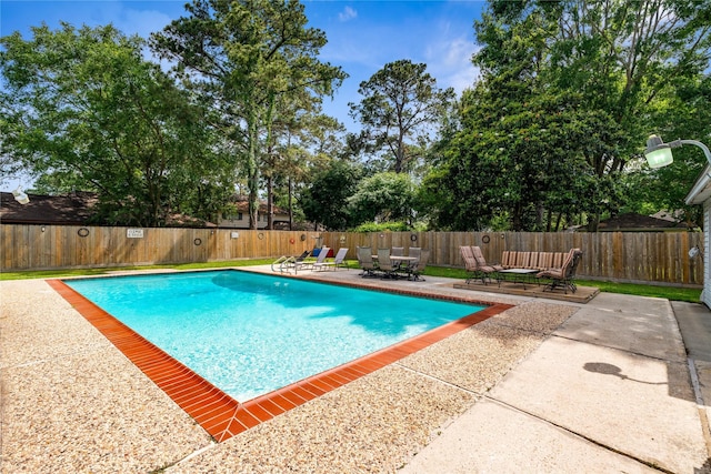 view of pool with a patio area, a fenced backyard, and outdoor dining space