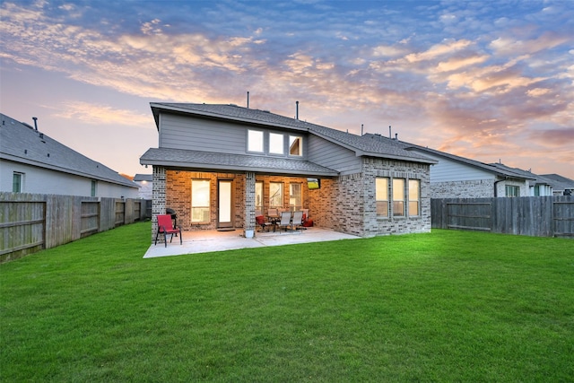 15606 Upper Lochton Dr, Humble, TX 77346 - back of house at dusk featuring brick siding, a patio, and a shingled roof