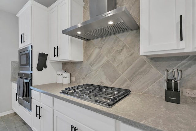 15606 Upper Lochton Dr, Humble, TX 77346 - kitchen featuring wall chimney exhaust hood, appliances with stainless steel finishes, decorative backsplash, and white cabinetry
