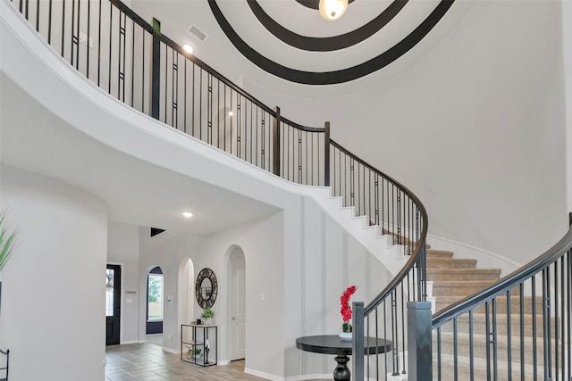 15606 Upper Lochton Dr, Humble, TX 77346 - stairway featuring a high ceiling, arched walkways, recessed lighting, baseboards, and tile patterned flooring