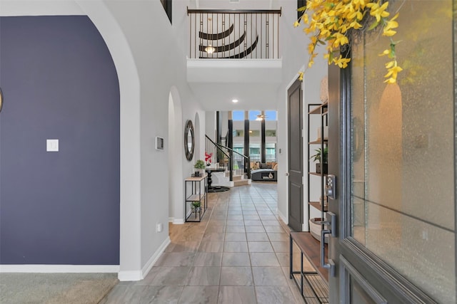 15606 Upper Lochton Dr, Humble, TX 77346 - entrance foyer with arched walkways, a towering ceiling, baseboards, and tile patterned flooring