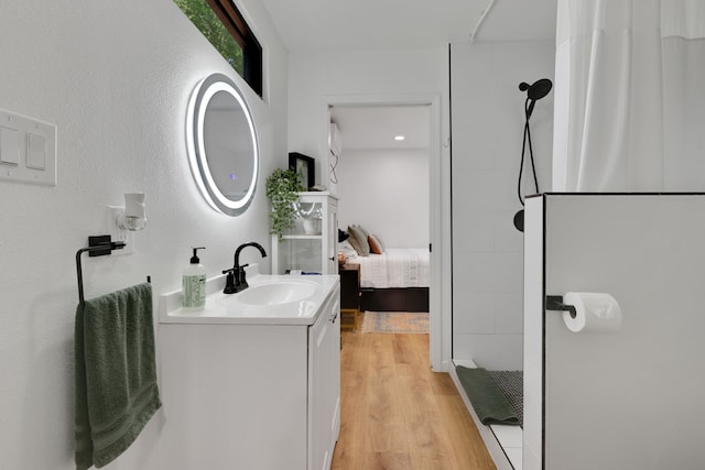 275 Fairview E, Livingston, TX 77351 - ensuite bathroom featuring tiled shower, wood finished floors, and vanity