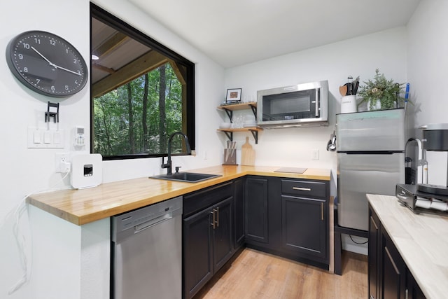 275 Fairview E, Livingston, TX 77351 - kitchen featuring appliances with stainless steel finishes, butcher block counters, a sink, and light wood-style floors