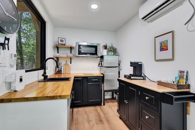 275 Fairview E, Livingston, TX 77351 - kitchen with wooden counters, appliances with stainless steel finishes, a sink, dark cabinetry, and an AC wall unit
