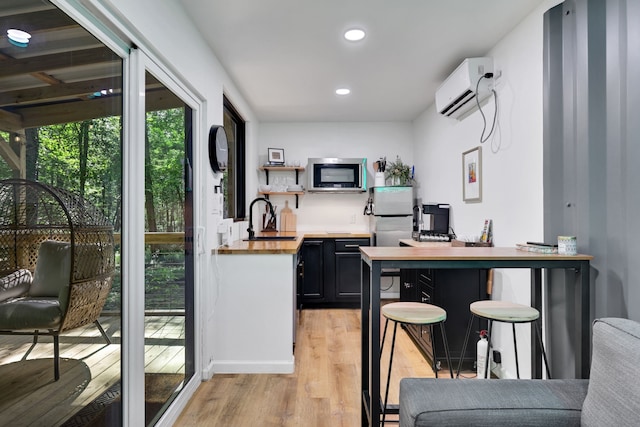 275 Fairview E, Livingston, TX 77351 - bar with appliances with stainless steel finishes, an AC wall unit, light wood-style flooring, recessed lighting, and a sink