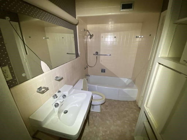 3755 Long Ave, Beaumont, TX 77706 - bathroom featuring toilet, washtub / shower combination, and tasteful backsplash