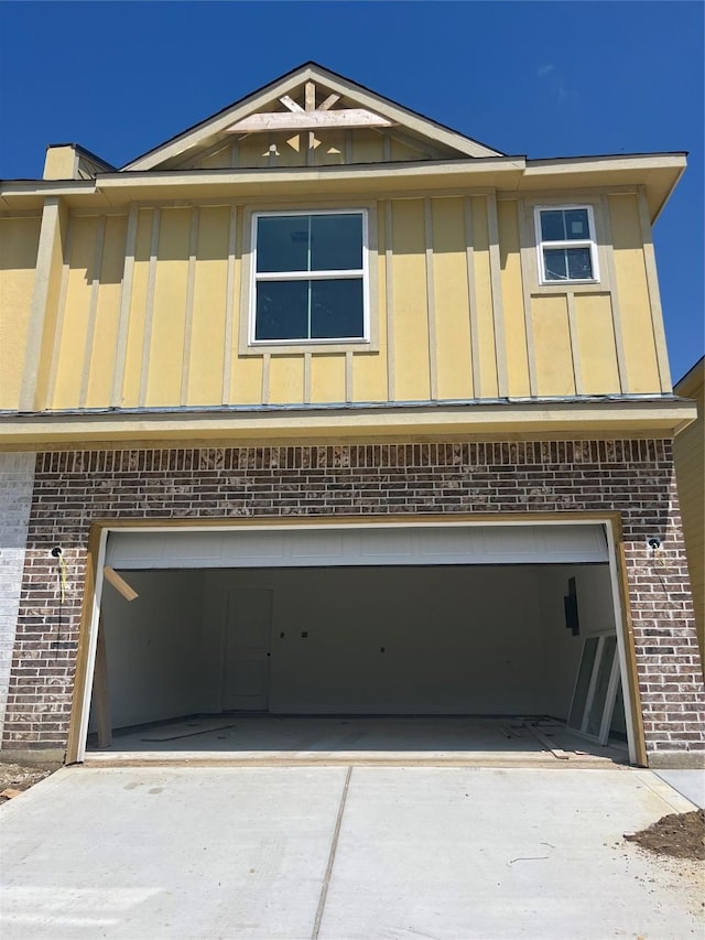 118 Capetown, Conroe, TX 77356 - view of front facade with brick siding, board and batten siding, an attached garage, and driveway