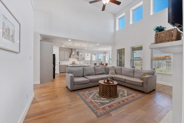 10059 Preserve Way, Conroe, TX 77385 - living room featuring ceiling fan, healthy amount of natural light, light wood-style flooring, and a towering ceiling