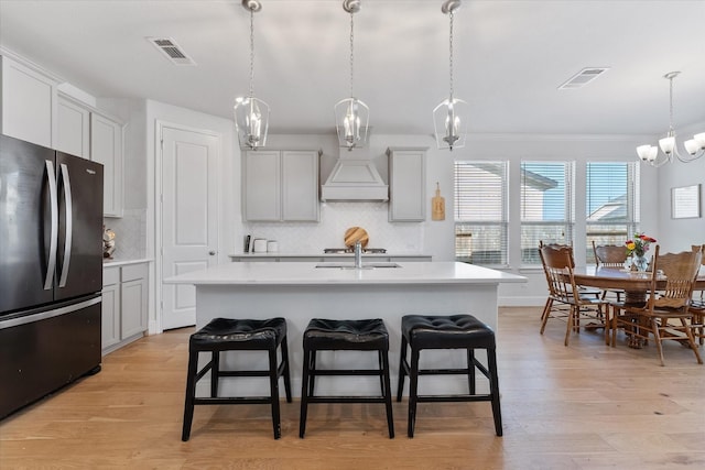 10059 Preserve Way, Conroe, TX 77385 - kitchen with freestanding refrigerator, light countertops, a kitchen breakfast bar, decorative backsplash, and crown molding