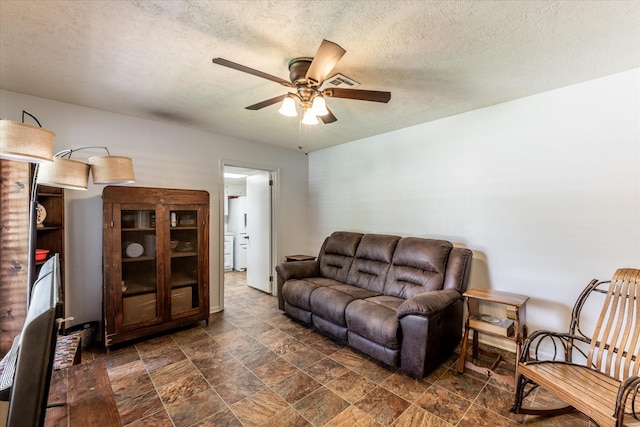 229 Willowbend St, Huntsville, TX 77320 - living area with ceiling fan, dark stone finish floors, and a textured ceiling