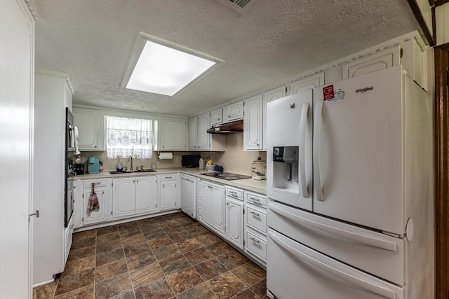 229 Willowbend St, Huntsville, TX 77320 - kitchen featuring white appliances, a sink, light countertops, stone finish flooring, and white cabinetry