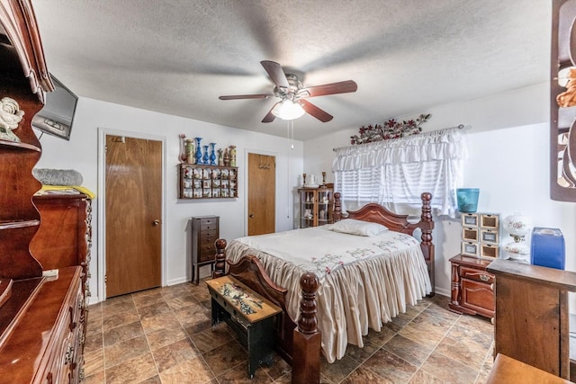 229 Willowbend St, Huntsville, TX 77320 - bedroom featuring stone finish floors, a textured ceiling, ceiling fan, and baseboards