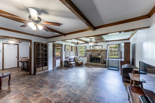 229 Willowbend St, Huntsville, TX 77320 - living area featuring ceiling fan, a fireplace, ornamental molding, wooden walls, and stone finish flooring