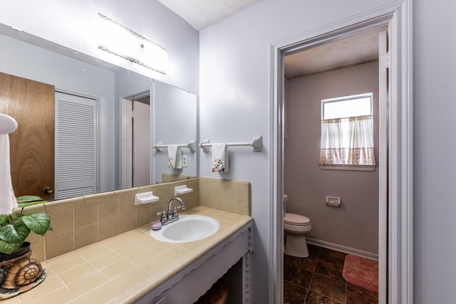 229 Willowbend St, Huntsville, TX 77320 - bathroom with toilet, backsplash, baseboards, and vanity