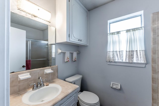 229 Willowbend St, Huntsville, TX 77320 - full bathroom featuring a stall shower, toilet, tasteful backsplash, and vanity