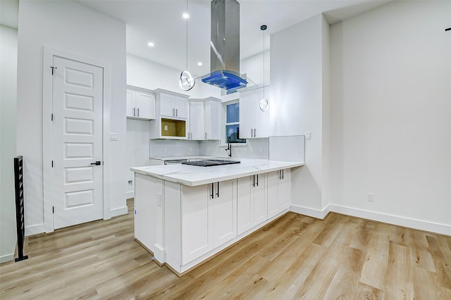1913 Hoskins Dr Unit D, Houston, TX 77080 - kitchen featuring island range hood, a peninsula, light wood-type flooring, white cabinets, and recessed lighting