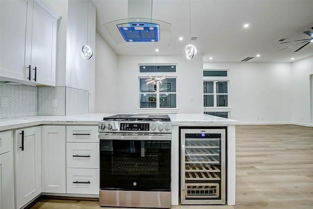 1913 Hoskins Dr Unit D, Houston, TX 77080 - kitchen featuring wine cooler, stainless steel gas range, light wood-style flooring, and white cabinetry