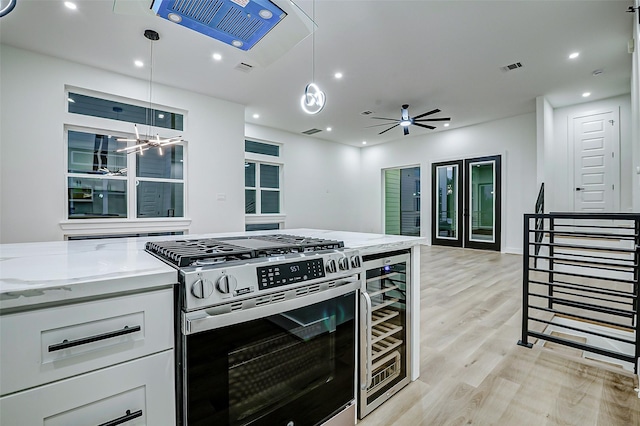 1913 Hoskins Dr Unit D, Houston, TX 77080 - kitchen featuring gas stove, beverage cooler, light wood finished floors, white cabinets, and light stone counters