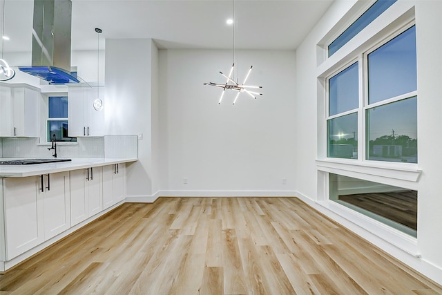 1913 Hoskins Dr Unit D, Houston, TX 77080 - kitchen featuring a chandelier, island exhaust hood, light wood-style floors, white cabinets, and recessed lighting