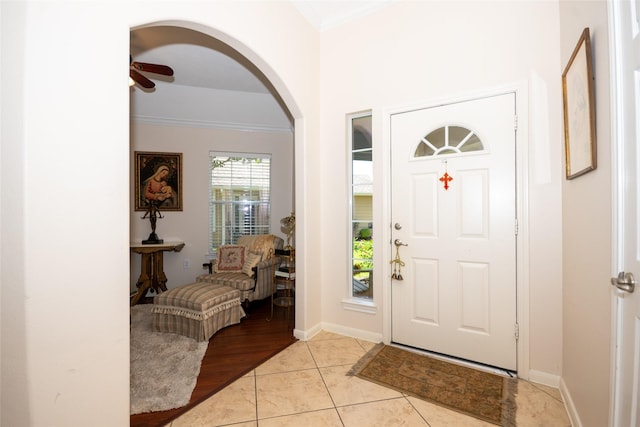 25230 Aspenlodge Ln, Katy, TX 77494 - foyer with crown molding, arched walkways, a ceiling fan, baseboards, and light tile patterned floors