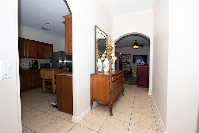 25230 Aspenlodge Ln, Katy, TX 77494 - hallway featuring arched walkways, ornamental molding, light tile patterned flooring, and baseboards