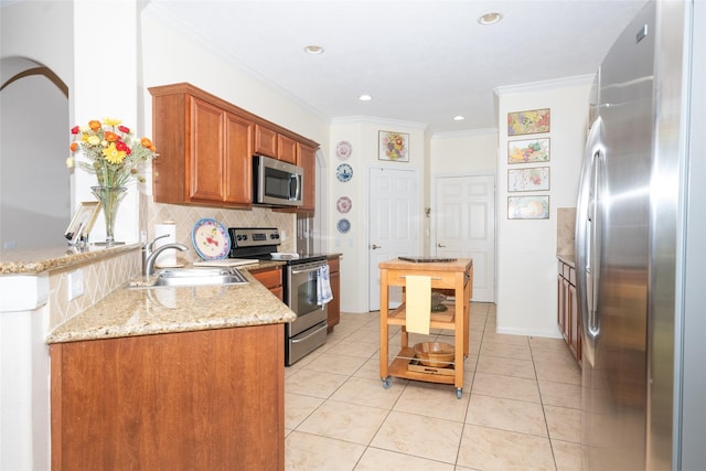25230 Aspenlodge Ln, Katy, TX 77494 - kitchen featuring appliances with stainless steel finishes, a sink, decorative backsplash, crown molding, and brown cabinets