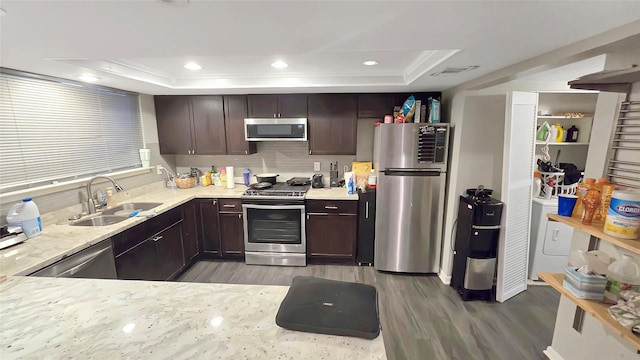 2263 Triway Ln, Houston, TX 77043 - kitchen featuring appliances with stainless steel finishes, a sink, wood finished floors, dark brown cabinets, and recessed lighting