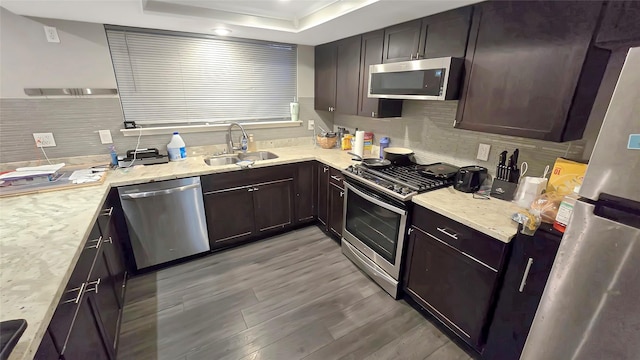 2263 Triway Ln, Houston, TX 77043 - kitchen with appliances with stainless steel finishes, a sink, light wood-type flooring, and tasteful backsplash