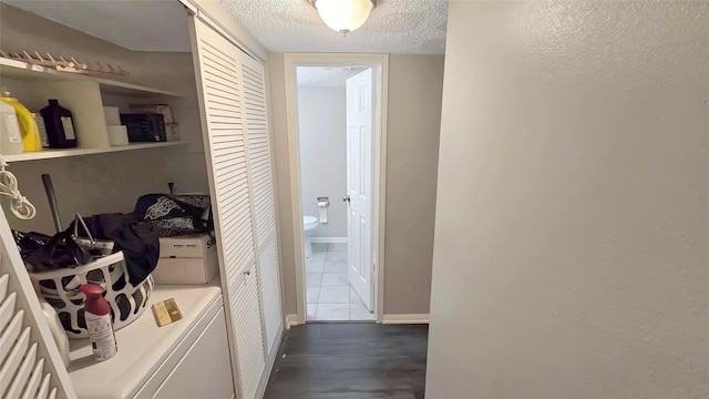 2263 Triway Ln, Houston, TX 77043 - hall with separate washer and dryer, a textured ceiling, and dark tile patterned floors
