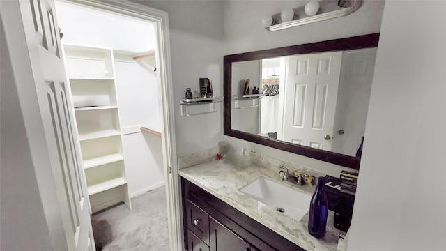 2263 Triway Ln, Houston, TX 77043 - bathroom with vanity, a walk in closet, and baseboards