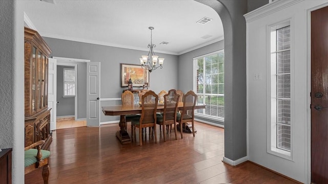 13402 Layton Castle Ln, Cypress, TX 77429 - dining space with dark wood-type flooring, arched walkways, crown molding, baseboards, and a chandelier