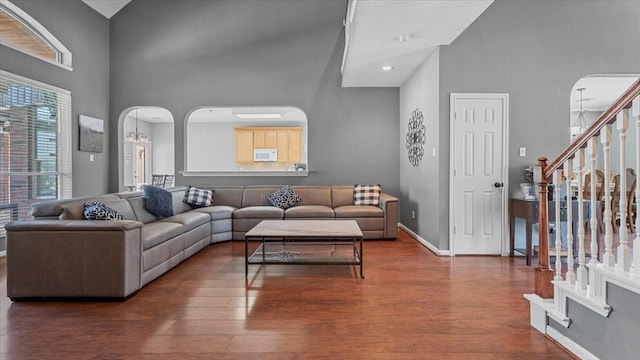 13402 Layton Castle Ln, Cypress, TX 77429 - living room featuring a high ceiling, arched walkways, wood finished floors, baseboards, and stairway