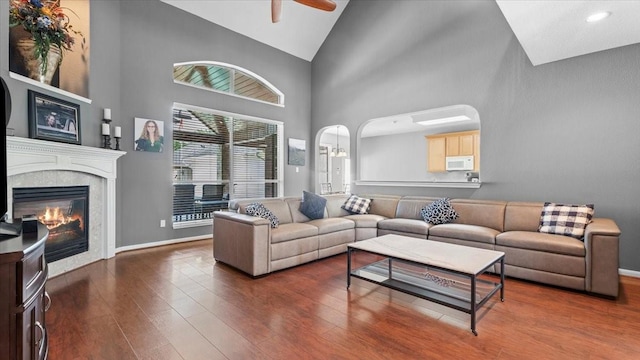 13402 Layton Castle Ln, Cypress, TX 77429 - living area featuring ceiling fan, wood finished floors, high vaulted ceiling, arched walkways, and baseboards