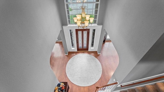 13402 Layton Castle Ln, Cypress, TX 77429 - entryway with a chandelier, stairs, a textured wall, wood finished floors, and a towering ceiling