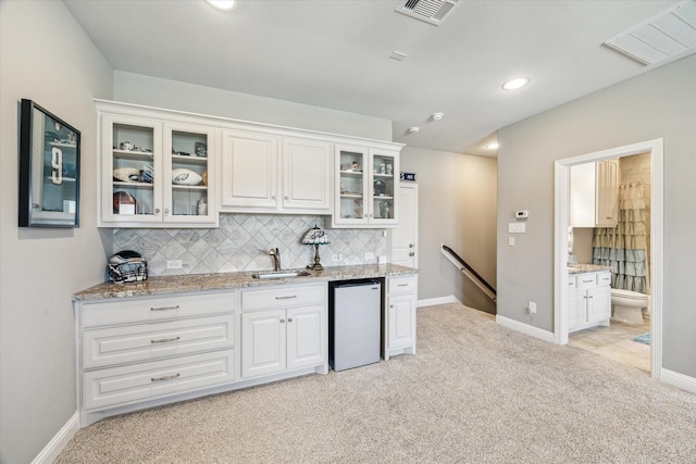 32319 Tall Oaks Way, Magnolia, TX 77354 - kitchen with a sink, fridge, light carpet, decorative backsplash, and light stone countertops