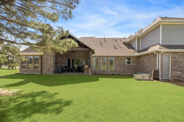 32319 Tall Oaks Way, Magnolia, TX 77354 - back of property featuring brick siding, a yard, a shingled roof, and a patio area