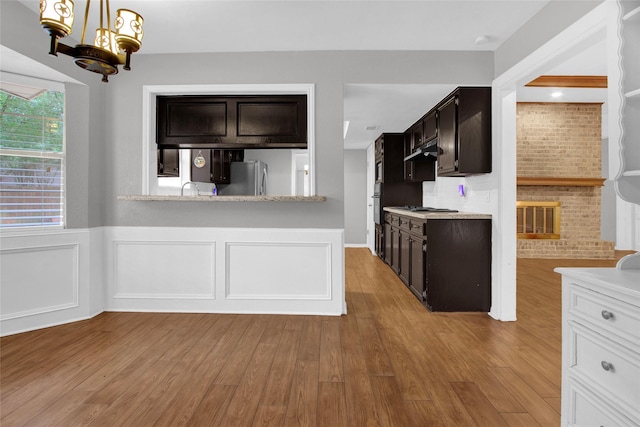 6214 Oak Masters Dr, Spring, TX 77379 - kitchen featuring freestanding refrigerator, a chandelier, light countertops, a wainscoted wall, and under cabinet range hood