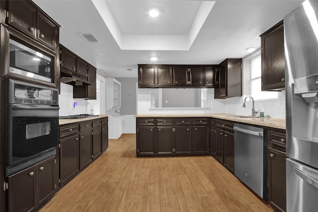 6214 Oak Masters Dr, Spring, TX 77379 - kitchen with appliances with stainless steel finishes, a sink, decorative backsplash, light wood-style floors, and dark brown cabinets