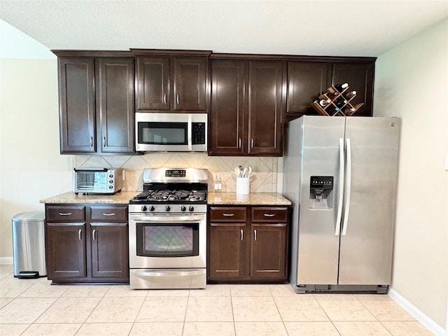 969 Gowan Dr, Conroe, TX 77301 - kitchen featuring appliances with stainless steel finishes, baseboards, decorative backsplash, and light tile patterned flooring