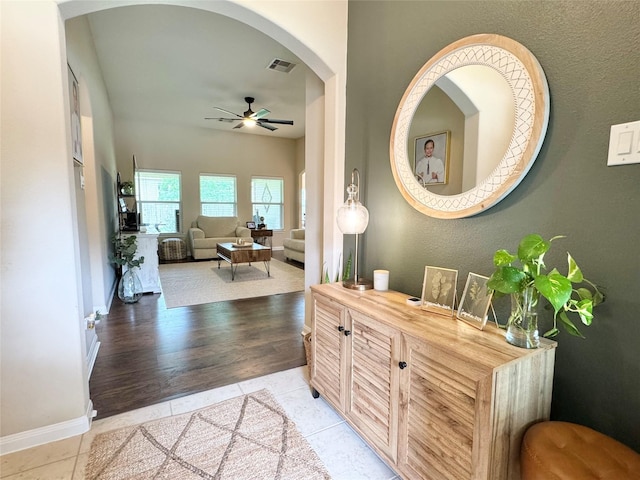 969 Gowan Dr, Conroe, TX 77301 - hallway with arched walkways, baseboards, and light tile patterned flooring