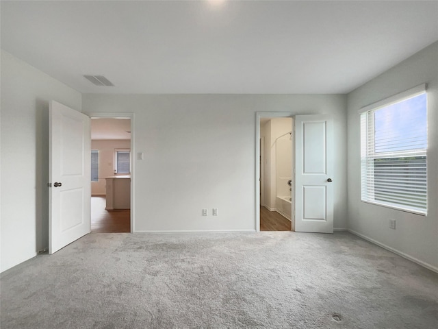 20011 Epirus Shores Dr, Hockley, TX 77447 - unfurnished bedroom featuring carpet floors, baseboards, and ensuite bathroom