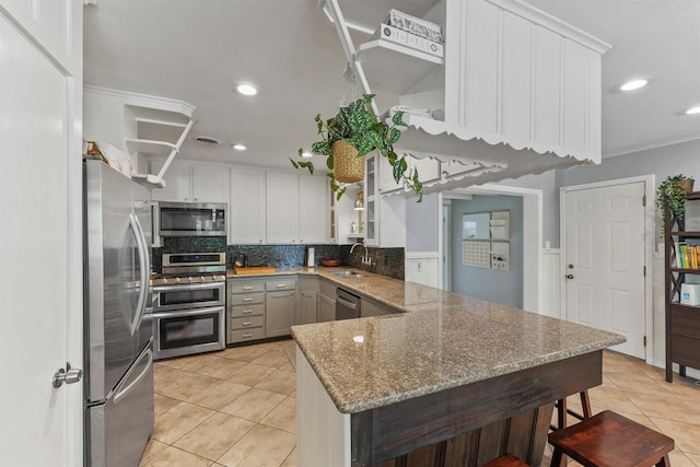 10438 Brinwood Dr, Houston, TX 77043 - kitchen featuring stainless steel appliances, open shelves, a peninsula, light tile patterned floors, and backsplash