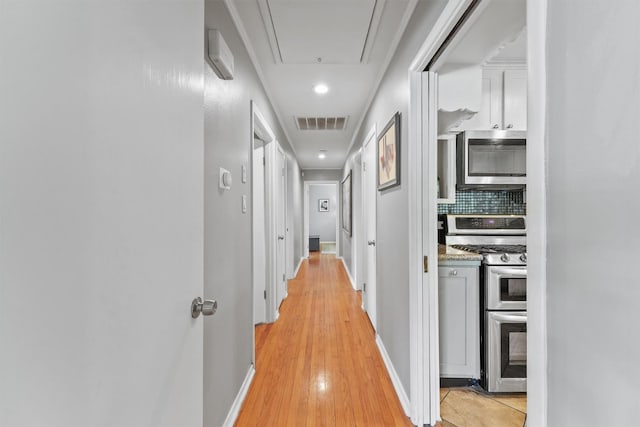 10438 Brinwood Dr, Houston, TX 77043 - hallway featuring attic access, light wood finished floors, and baseboards