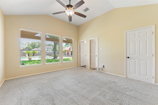 carpeted spare room with lofted ceiling, a ceiling fan, and baseboards