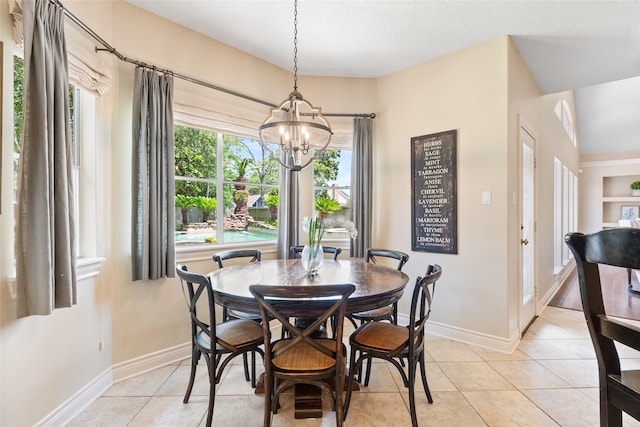 dining space featuring a chandelier, baseboards, and light tile patterned flooring