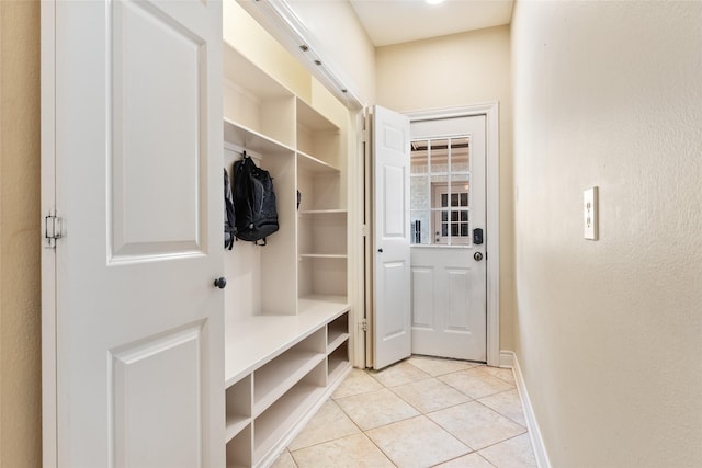 mudroom with light tile patterned floors and baseboards